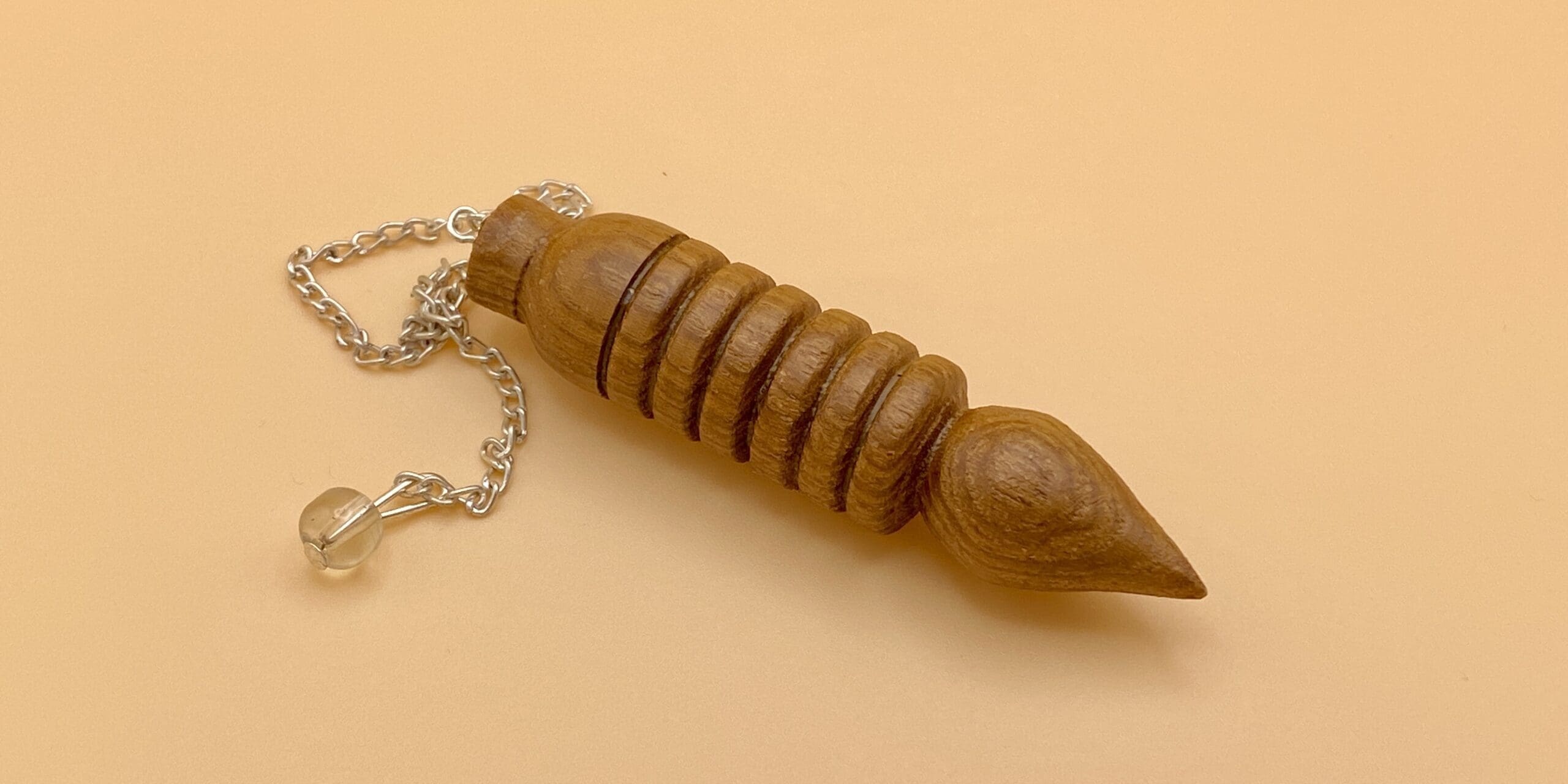 Péndulo Osiris de madera natural con seis anillos o baterias