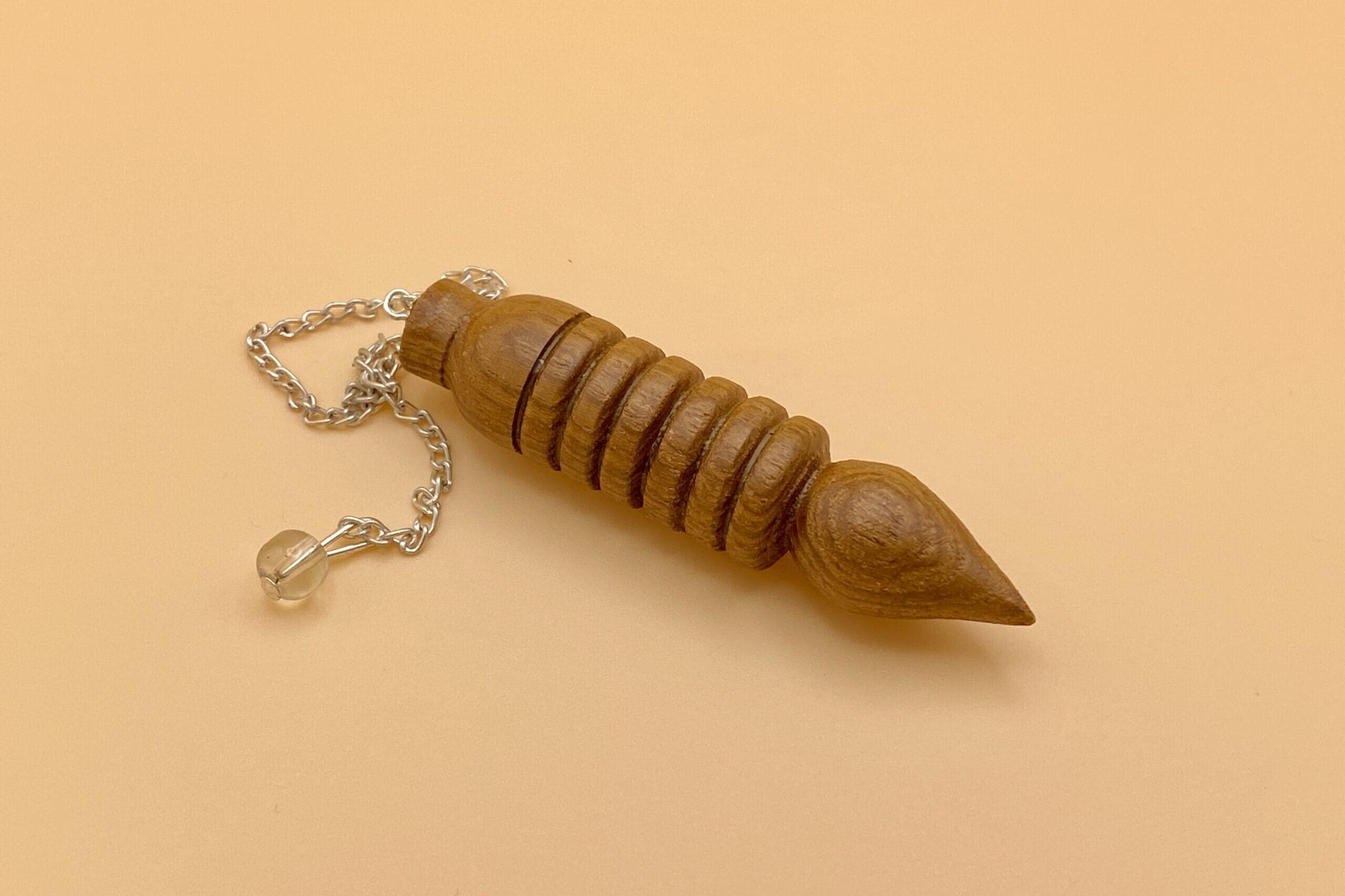 Péndulo Osiris de madera natural con seis anillos o baterias