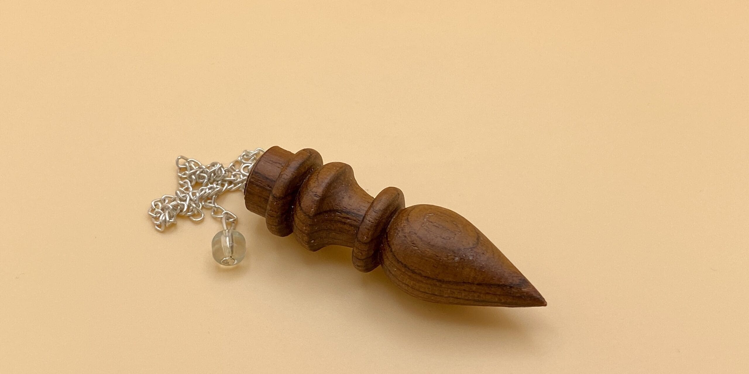 Péndulo egipcio de madera natural con un anillo