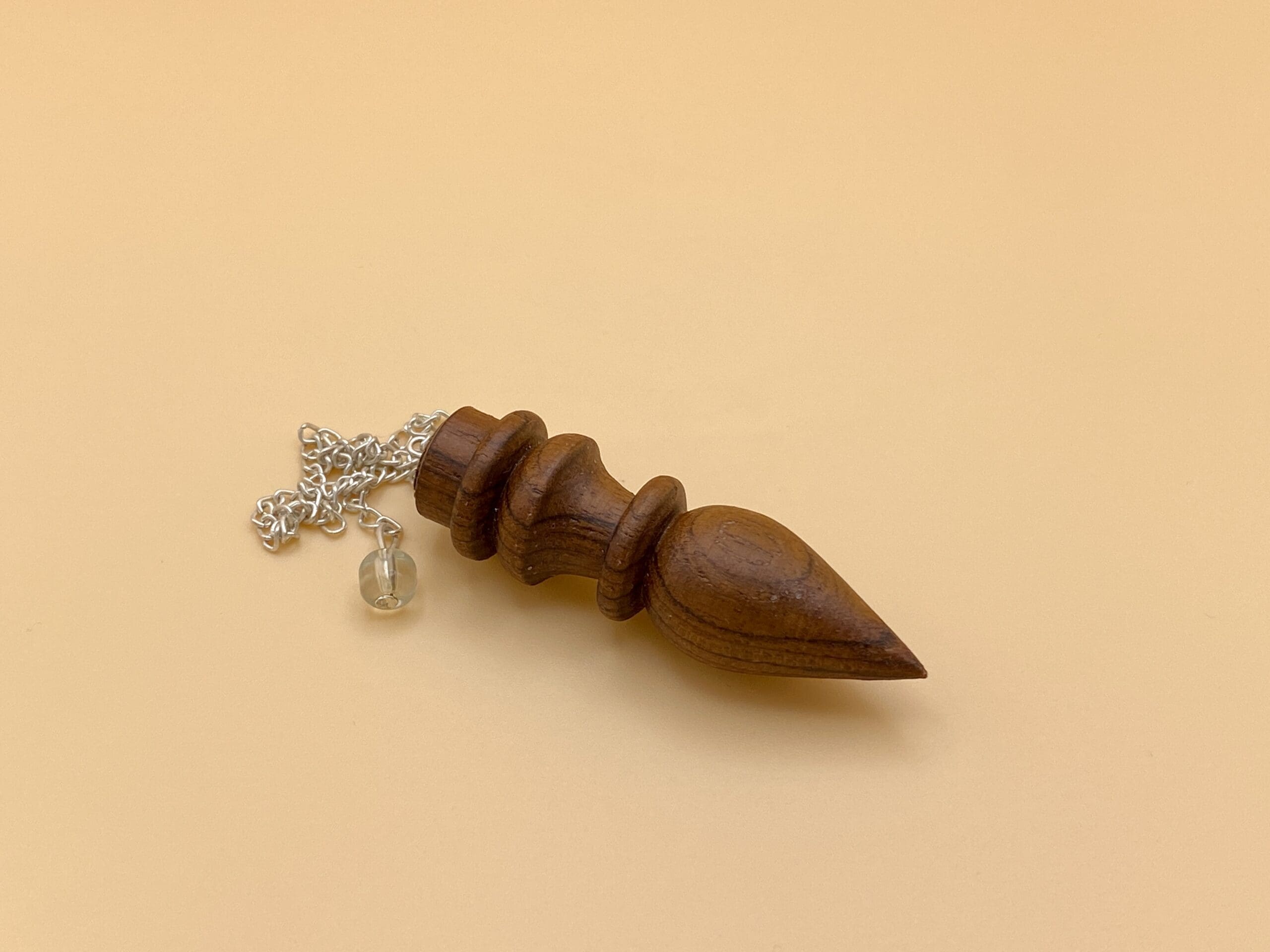 Péndulo egipcio de madera natural con un anillo