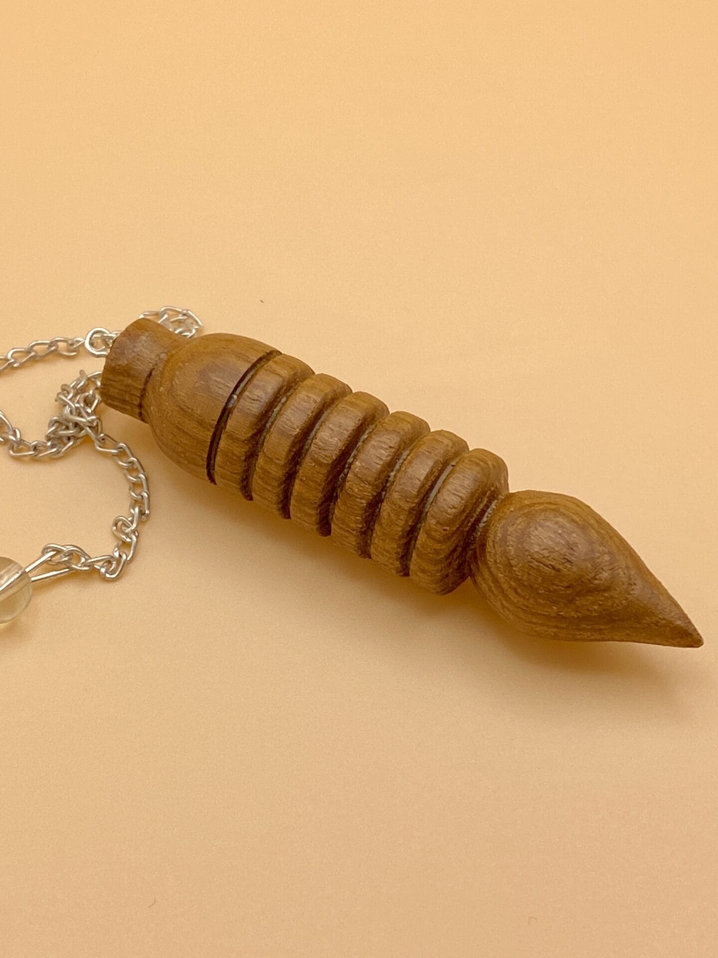 Péndulo Karnak de madera natural con seis anillos o baterias